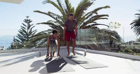 Active Diverse Duo Practicing Yoga on Scenic Rooftop