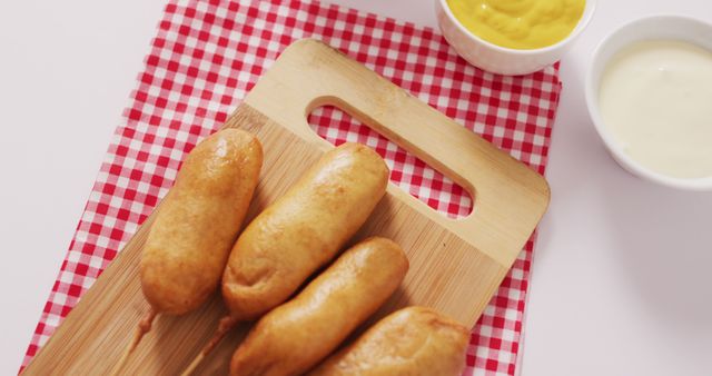 Image of corn dogs with dips on a white surface. food, cuisine and catering ingredients.