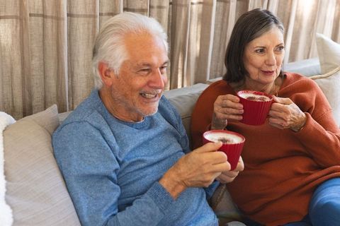 Senior couple enjoying warm beverages in cozy living room