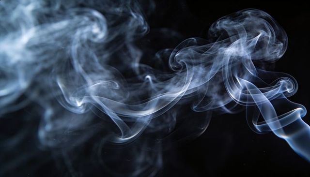 Blue-white smoke swirls against black backdrop, translucent ribbons and spirals