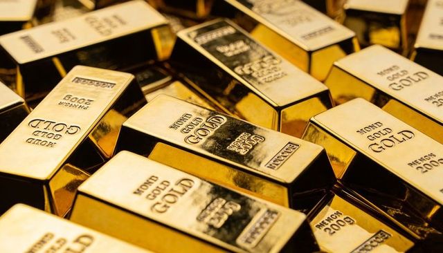 Stacking gold bullion bars reflecting light in vault for investment, wealth, luxury reserve