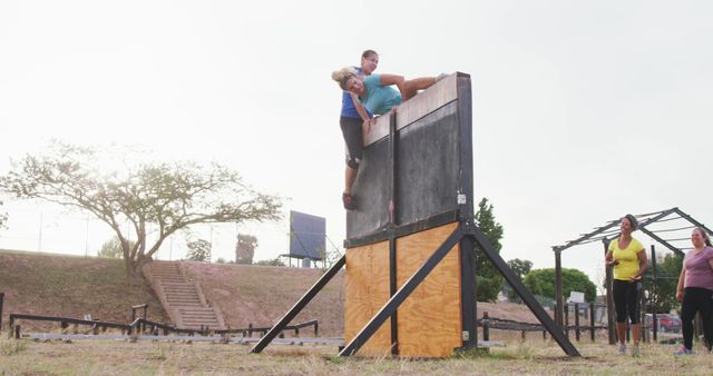 Group of Athletes Climbing Over Obstacle Wall in Outdoor Training - Download Free Stock Images Pikwizard.com