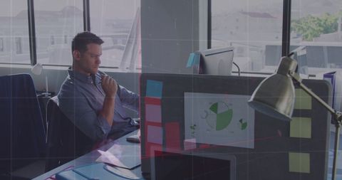 Focused Businessman Analyzing Data on Laptop in Modern Office