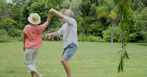Senior Couple Dancing Joyfully in Garden