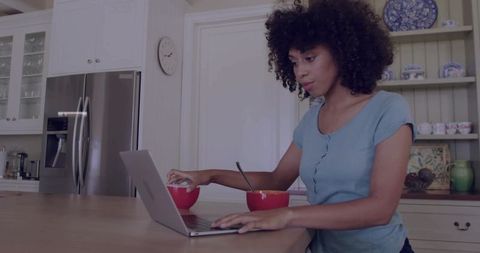 Woman Typing on Laptop During Breakfast in Modern Cozy Kitchen