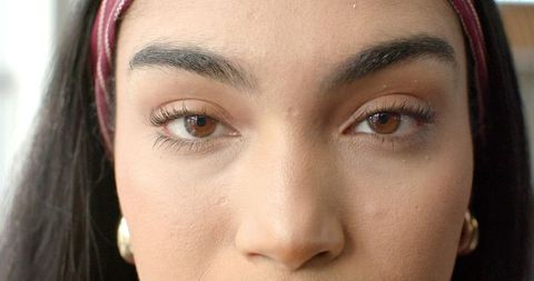 Holding steady gaze closeup with maroon headband and gold hoop earrings