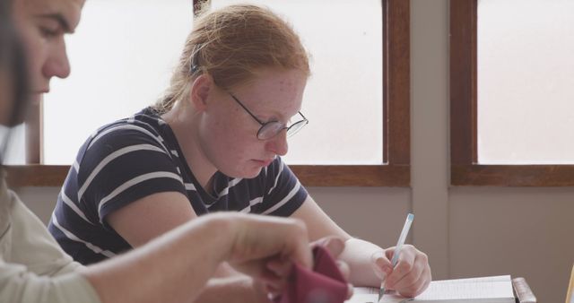 Focused Student Studying at Table with Notebook and Pen - Download Free Stock Images Pikwizard.com