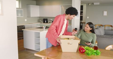 Couple Unpacking Groceries in Modern Kitchen with Smiles