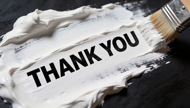 Bold thank you lettering on white paint smear with brush, high-contrast close-up texture