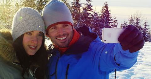 Happy Couple Taking Selfie in Snowy Winter Landscape