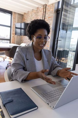 Professional woman engaging in online meeting from modern urban office