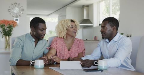 Friends Reviewing Documents at Home Amid Laughter
