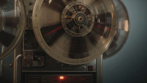 Spinning clear reel-to-reel tape recorder showing motion blur and vintage machinery detail