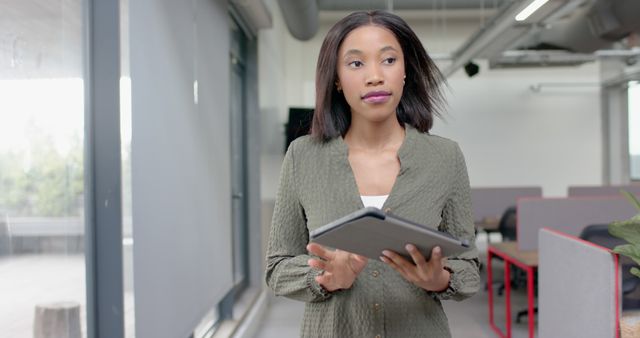 Focused Businesswoman Holding Tablet in Modern Office - Download Free Stock Images Pikwizard.com