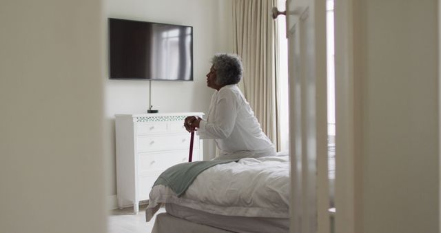 Elderly Woman Sitting on Bed with Walking Cane - Download Free Stock Images Pikwizard.com