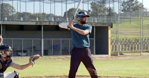 Batter Preparing to Swing at Plate with Catcher Reaching for Pitch on Ballpark Field Ready