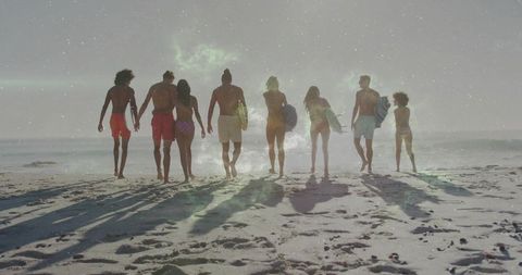 Group of Young Surfers Walking Towards Ocean Holding Surfboards