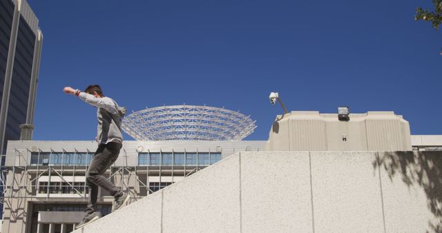 Man Practicing Parkour in Urban Environment with Blue Sky - Download Free Stock Images Pikwizard.com