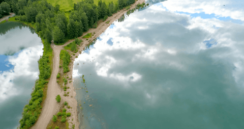 transparent clouds reflecting pristine lake and dirt path - Download Free Stock Videos Pikwizard.com