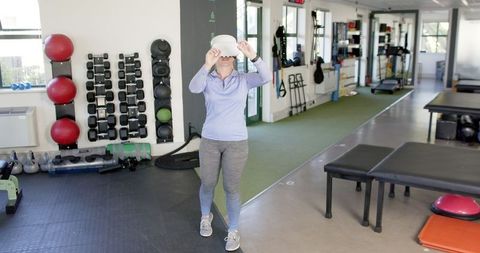 Woman Using VR Headset for Physical Therapy in Rehabilitation Center