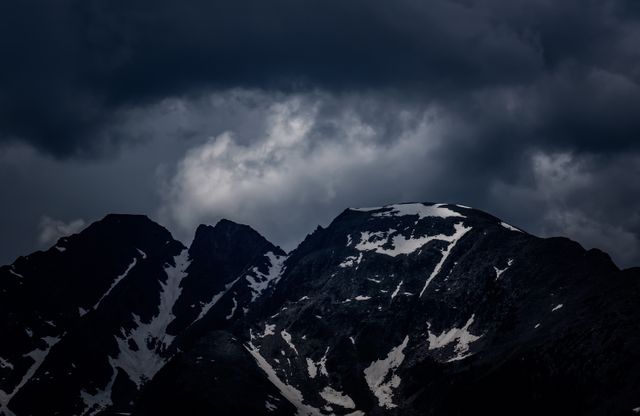 Dark Moody Clouds Over Snowcapped Mountain Peaks at Dusk - Download Free Stock Photos Pikwizard.com