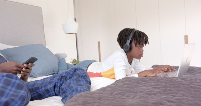 Child Using Laptop on Bed While Wearing Headphones - Download Free Stock Images Pikwizard.com