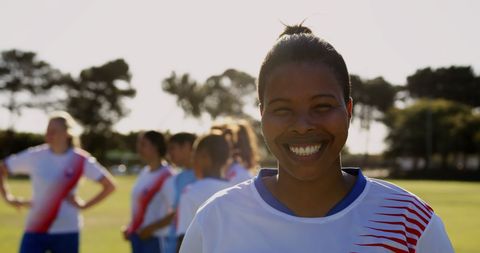 Confident Female Soccer Player Smiling on Field