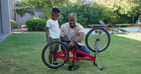 Father and Son Repairing Bicycle Together Outdoors