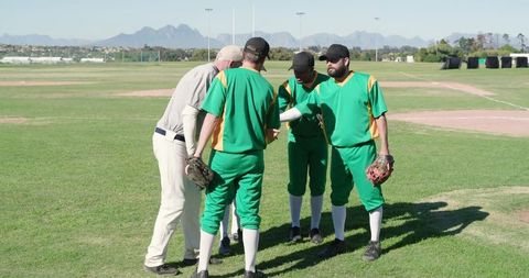 Baseball team huddling on field studying lineup card and planning game strategy
