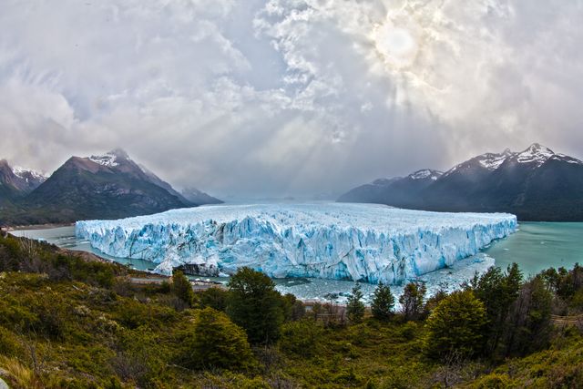 Panoramic View of Perito Moreno Glacier with Sunbeams Through Clouds - Download Free Stock Photos Pikwizard.com