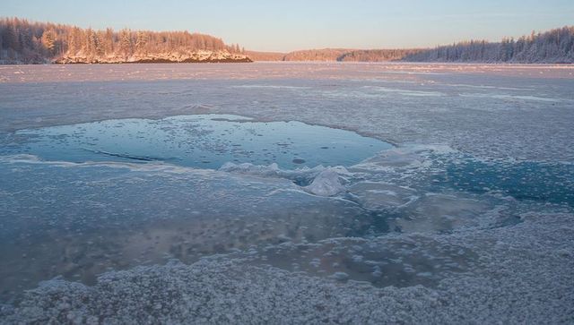 Reflection on Frozen Winter Lake with Open Water Patch