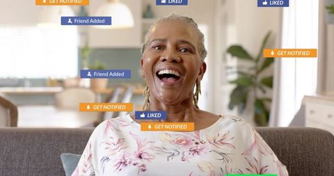 Joyful senior woman laughing on sofa surrounded by social media notifications and likes