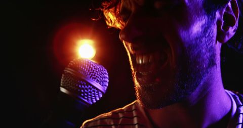 Passionate Male Singer Performing on Stage with Microphone - Download Free Stock Images Pikwizard.com