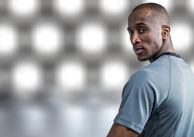 Portrait of confident athlete standing against white grey background