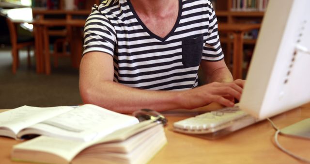 Student Typing on Computer in Library with Open Books - Download Free Stock Images Pikwizard.com