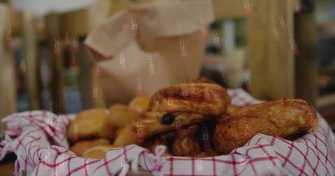 Rustic basket of fresh golden croissants and buns on checkered cloth at market stall