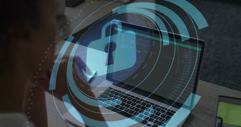 Female analyst reviewing laptop code with digital padlock hud representing cybersecurity protection
