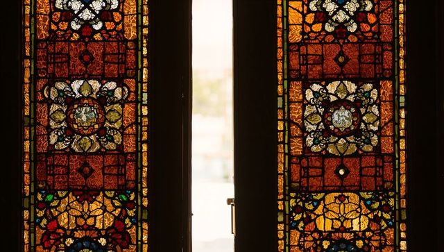 Intricate stained glass church doorway with brass handle