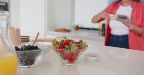 Woman Prepares Healthy Breakfast in Modern Kitchen with Fresh Berries
