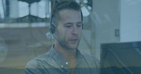 Businessman Utilizing Headset amid Digital Interfaces for Data Processing