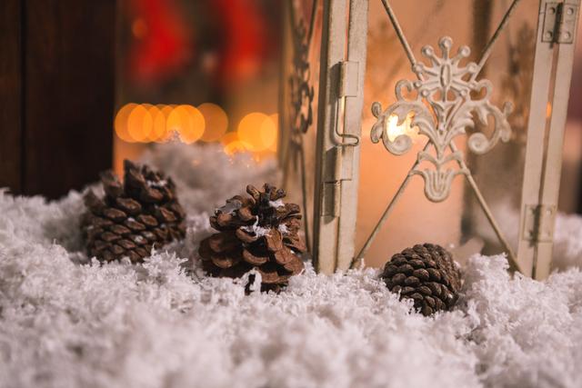 Pine Cones on Fake Snow with Lantern During Christmas - Download Free Stock Photos Pikwizard.com