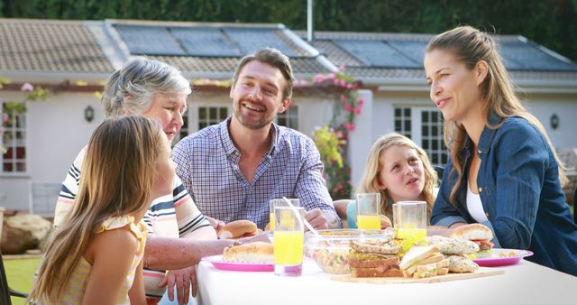 Family Enjoying Outdoor Meal in Garden with Sandwiches and Juices - Download Free Stock Images Pikwizard.com