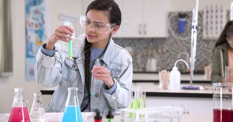 Teenage girl conducting chemistry experiment in school lab
