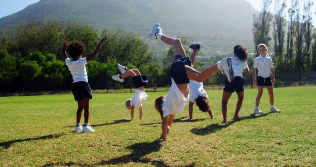 Outdoor Fun Children Doing Cartwheels on Field - Download Free Stock Images Pikwizard.com