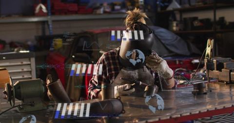 Female welder inspecting metal part at workbench with augmented reality data overlay