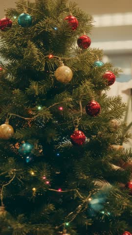 Man wearing lanyard adjusting office Christmas tree lights and ornaments in vertical video