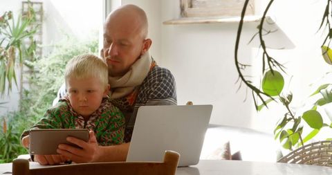 Father and Son Using Tablet Together at Home Garden