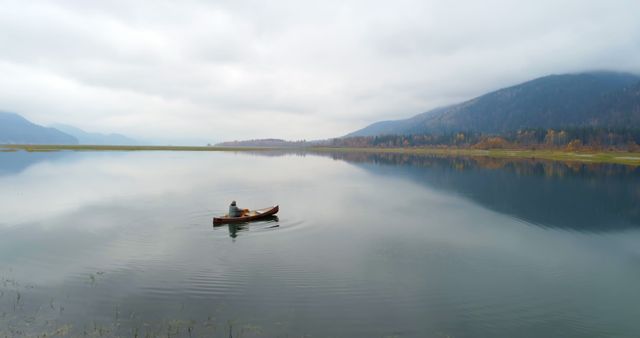 Caucasian man enjoys a serene canoe trip on a calm lake, with copy space - Download Free Stock Photos Pikwizard.com