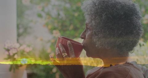 Senior African-American woman sipping coffee on porch at sunset with serene garden overlay