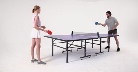 Friends playing table tennis for recreation and fitness